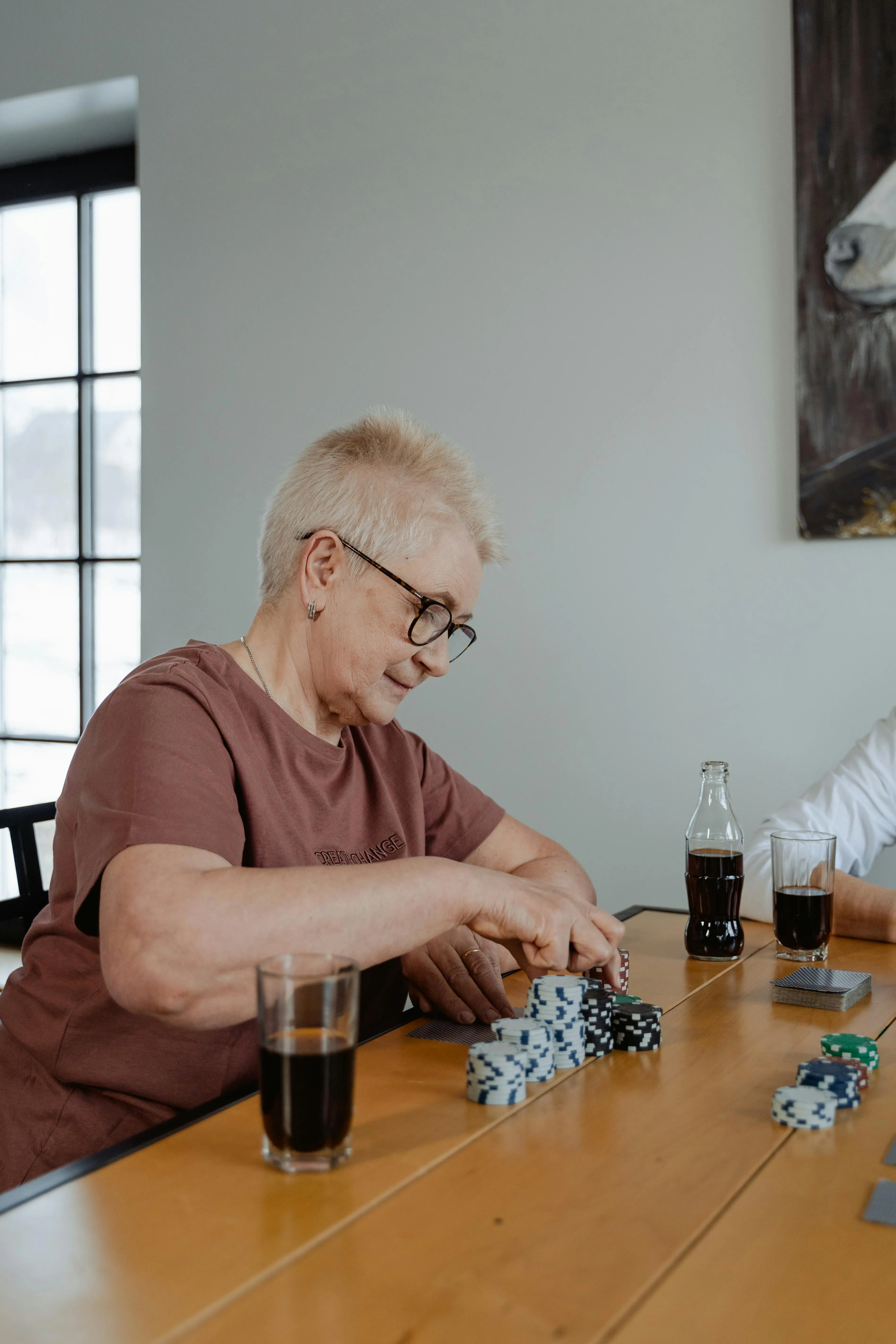 Mãos manuseando peças de dominó em sessão de reabilitação neuropsicológica